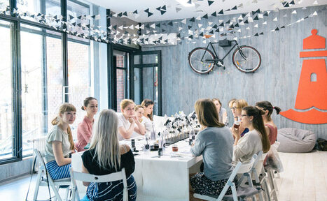 Арендовать Стильный лофт в скандинавском стиле. Вход с улицы. Девушки за общим столом в лофте на празднике. 