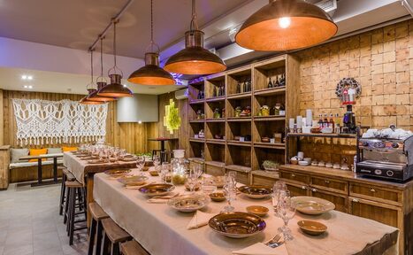 Арендовать Нора. Оборудованный зал. Столы с сервировкой. Подвесные лампы