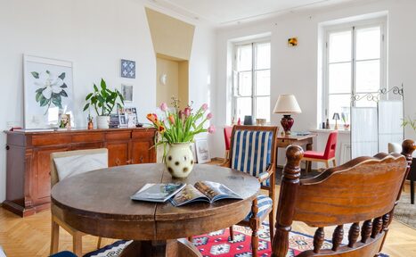 Арендовать Светлый лофт с панорамным видом. Светлый зал. Круглый стол с цветком и журналами