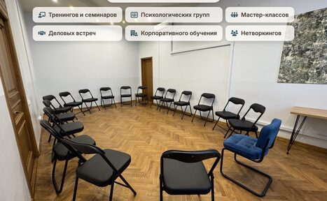 Арендовать Зал для тренингов и мастер-классов. Овальная комната с паркетным полом, расставлены черные складные стулья по периметру, один синий стул. На стене картина. Стены светлые, два деревянных дверных проема, деревянный стол у стены. Верхнее освещение. Текст: перечень мероприятий.