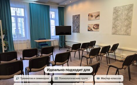 Арендовать Зал для мероприятий, тренингов, семинаров. Конференц-зал с рядами стульев, экраном, деревянным столом. Белые стены с несколькими картинами. Голубые шторы на окнах. Лампы в потолке. На переднем плане текст о применении пространства.