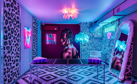 Арендовать Неоновый лофт Гламур. Квадратное помещение с чёрно-белым геометрическим полом. В центре — стол для пинг-понга с розовыми пластиковыми стаканами. Стены украшены неоновыми вывесками, постерами и зеркалом в пухлой раме. Освещение фиолетового оттенка, на потолке люстра.