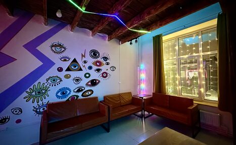 Арендовать Яркий двухуровневый лофт. Приглушённый свет. Диваны. Стена с рисунками. Окно со светящейся гирляндой