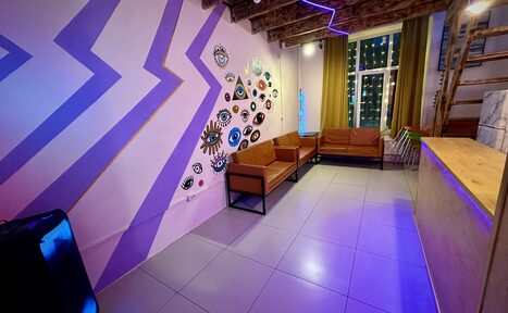 Арендовать Яркий двухуровневый лофт. Разукрашенные стены с рисунками. Диваны. В углу колонка. Барная стойка