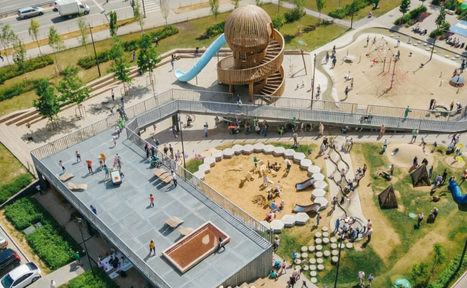 Арендовать Площадка в Москве c одной фотографией. Детская площадка с башней и спиральной лестницей, голубая горка. Песочница окружена скамейками. Асфальтовые и деревянные дорожки. Зелёные насаждения. Деревянные и верёвочные конструкции для лазания. Люди и дети гуляют и играют.