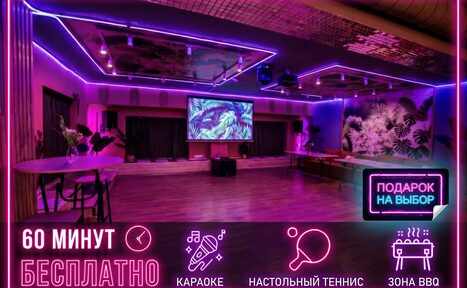 Арендовать Тропический лофт с современным дизайном и верандой. Просторное помещение с неоновым освещением и деревянным полом. В центре проектор с экраном, рядом столы и стулья. На заднем плане декоративная стена с растительным рисунком. Знаки: "60 минут бесплатно", "Подарок на выбор", иконки караоке, тенниса, зоны BBQ.