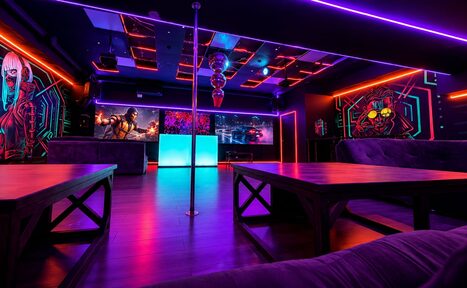 Арендовать Cyberpunk (Киберпанк). Изображение показывает клубное пространство с деревянным полом и мягкой мебелью. На переднем плане столы. Потолок с неоновыми панелями. Светодиодное освещение фиолетовых и красных тонов. Стены украшены яркими граффити. В центре вертикальный шест.