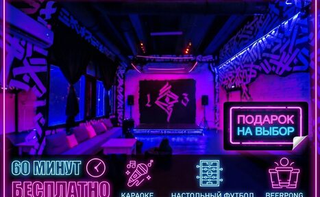 Арендовать Мультиформатный лофт-зал. Просторная комната для мероприятий с неоновым освещением, граффити на стенах, мягкими диванами вдоль окна и сценой. На переднем плане неоновая вывеска "Подарок на выбор". Тексты: "60 минут бесплатно", "Караоке", "Настольный футбол", "Beerpong".
