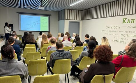 Арендовать Зал 6. Просторный и светлый конференц-зал до 50 человек в Академии Кантаты. Конференц-зал с рядами желтых кресел, люди сидят и смотрят на экран с презентацией. Потолок с линейными светильниками, стены белые с надписями. Справа текст на русском языке о честности и этике.