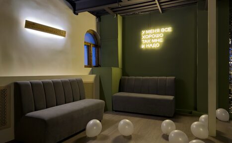 Арендовать Maybe Loft (Мэйби Лофт). Зал Olive (Олив). Современный дизайнерский лофт . Пространство с мягкими серыми диванами, зелеными стенами, декорированное светящейся надписью. На полу разбросаны белые воздушные шары. Стена с арочным окном, светодиодное освещение.