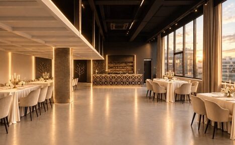 Арендовать Loft Prostranstvo Huge(Огромное Лофт Пространство). Просторное помещение с панорамными окнами и бетонным полом. Столы накрыты белыми скатертями, окружены мягкими стульями. По периметру расставлены свечи. На стене темная барная стойка с декоративной решеткой. Мягкое потолочное освещение.