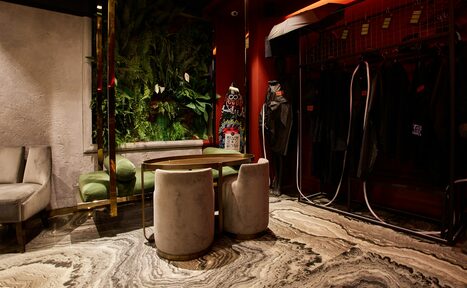 Арендовать Микс Afterparty(После вечеринки). Лофт со столом и стульями, зеленый диван, вертикальный сад с растениями, вешалки с одеждой. Декор в темно-красных тонах, текстуры из камня и дерева. Освещение точечное, пол мраморный с узором.