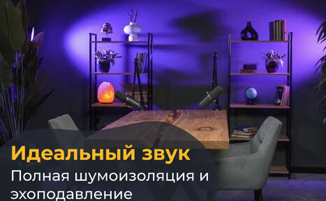 Арендовать Лофт  Эйфория. Студия с деревянным столом, двумя микрофонами, двумя серыми креслами. На заднем плане две книжные полки с декором и книгами. Освещение фиолетовое, декоративный свет. На фото текст: "Идеальный звук. Полная шумоизоляция и эхоподавление".
