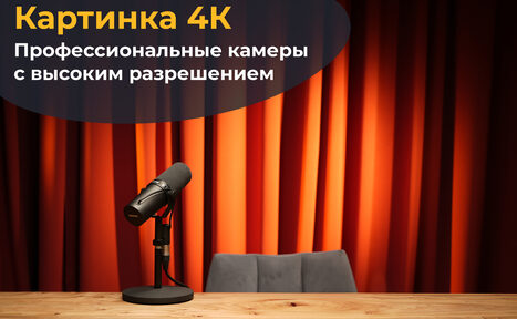 Арендовать Лофт  Эйфория. Стол с деревянной поверхностью, на котором стоит черный микрофон на стойке, перед серым креслом. На заднем плане оранжевые акустические шторы. Надпись: «Картинка 4К. Профессиональные камеры с высоким разрешением».