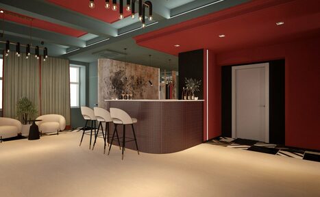 Арендовать Стильное пространство Астрид. Многофункциональное помещение с барной стойкой в центре, за которой размещены три стула. Слева зона отдыха с двумя креслами и растением. Потолок темный с подвесными светильниками. Стены окрашены в красный цвет, пол светлый, на стене крупная картина.