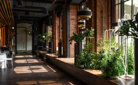 Арендовать Zafferano Loft(Зафферано лофт). Лофт-пространство с кирпичными стенами и большими окнами. Темный потолок с открытыми коммуникациями. Деревянный пол и подиум с растениями. Металлические конструкции, светильники подвесные. Естественное освещение. Стулья и столы из прозрачного пластика.