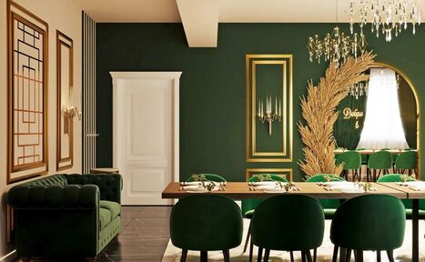 Арендовать Голливуд. Элегантный лофт в зелено-бежевых оттенках. Зал с тёмно-зелёными стенами, декорированными золотыми рамками. Длинный деревянный стол с зелёными стульями, на столе посуда и салфетки. Зелёный диван в углу. Люстра с подвесками, декоративное растение, белая дверь, текст «Добро».
