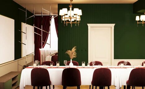 Арендовать Вегас. Атмосферный лофт с акцентным дизайном. Простор с длинным столом, накрытым белой скатертью, окружённый бордовыми стульями. Зеленая стена с белой дверью, золотые люстры, тёмно-красные шторы. Декор на столе из сухих растений в вазе. Светлое деревянное напольное покрытие.