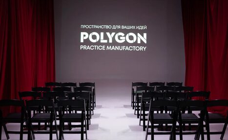 Арендовать Polygon(Полигон). Зал Вышка. Аудитория с черными стульями, расположенными рядами перед белым экраном с надписью "Пространство для ваших идей POLYGON Practice Manufactory". Красные занавески по бокам. Освещение мягкое, пол белый.
