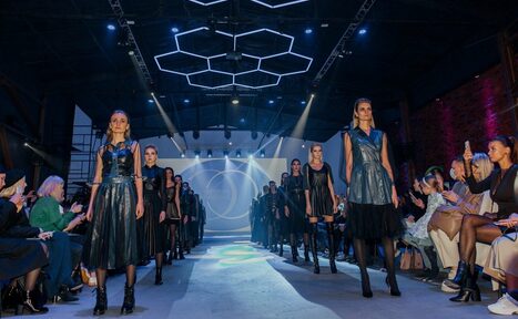 Арендовать Studio Hall(Студио Холл). Показ мод в просторном помещении с высокой потолочной конструкцией и геометрическим световым декором. Центральный подиум освещён прожекторами. С каждой стороны подиума зрители на стульях. Стены из кирпича. На заднем плане экран с визуальными проекциями.