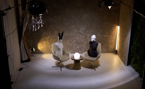 Арендовать WhiteFox Studio(Студия Белая Лиса). Стильное пространство с двумя креслами и маленьким столиком посередине. На креслах размещены манекены. На фоне фактурная стена и вертикальный светильник. Освещение мягкое, дополнительный свет от потолочных ламп. Полы светлые.