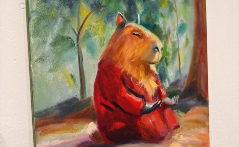 Арендовать Унца Унца. Уютный дофаминовый кабинетик с большими зеркалами. Картина с изображением капибары в красной одежде, сидящей в медитативной позе на фоне леса. Цветовая гамма включает зелёные, красные и коричневые оттенки. Холст висит на светлой стене.