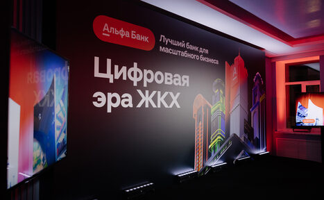 Арендовать Дом Жилищного Работника. Тип пространства: конференц-зал. Планировка: прямоугольная. Мебель/оборудование: телевизор на стене. Освещение: неоновая подсветка. Материалы: текстиль на стенах. Цвета: черный, красный, белый, разноцветные элементы. Надписи: «Цифровая эра ЖКХ», «Лучший банк для масштабного бизнеса».