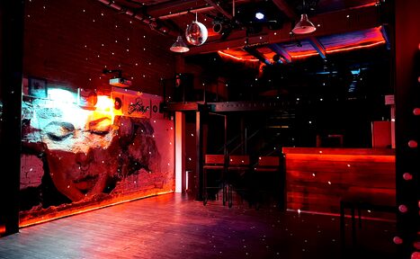 Арендовать Soul Loft . Девушки сидят полке в яркой комнате лофта, позируют на камеру, все улыбаются 