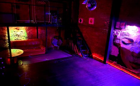 Арендовать Soul Loft . Отдельная комната в лофте с принадлежностями для кальянов, на стене висят виниловые пластинки, на другой стене красками изображён мужчина
