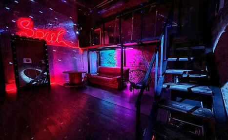 Арендовать Soul Loft . Светлая комната лофта, девушки проводят творческое мероприятие, суша фенами свои рисунки. Стоит большой стол. на них лежат разноцветные краски. На заднем плане шарики и большое зеркало