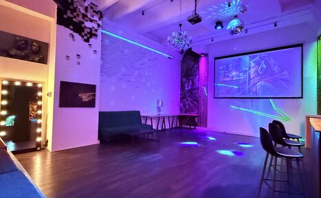 Арендовать Barshowplace (БарШоуПлейс). Лофт для вечеринок с коктейльным баром . Многофункциональное пространство с белыми кирпичными стенами и деревянным полом, оснащенное проектором, стульями, диваном и гримерным зеркалом. Современное освещение с элементами неона, диско-шар на потолке, абстрактное искусство на стенах.
