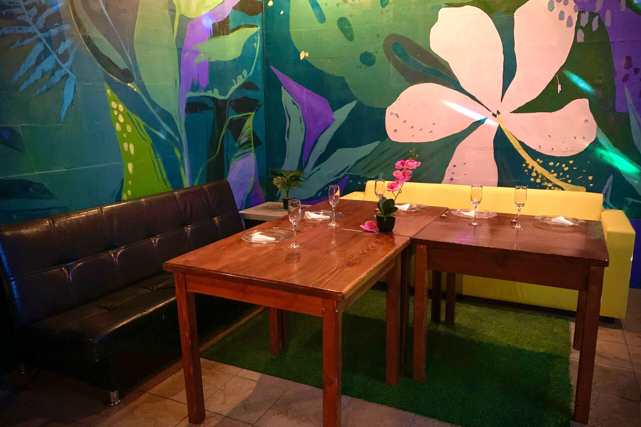 Арендовать Уютный тропический лофт. Столы с бокалами. Диваны. Небольшой цветок в горшке