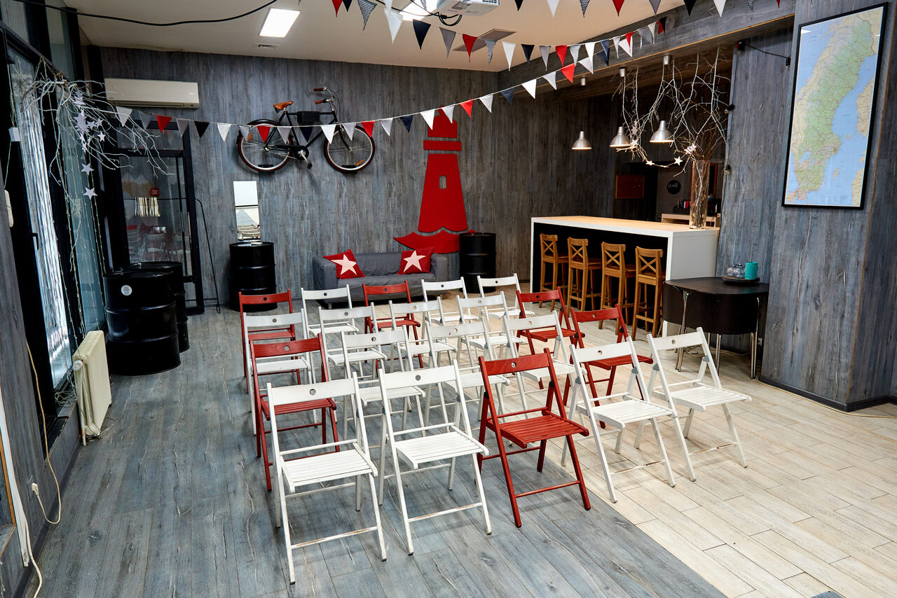 Арендовать Стильный лофт в скандинавском стиле. Вход с улицы. Сладные стулья в формате конференции, вид зала со сцены.