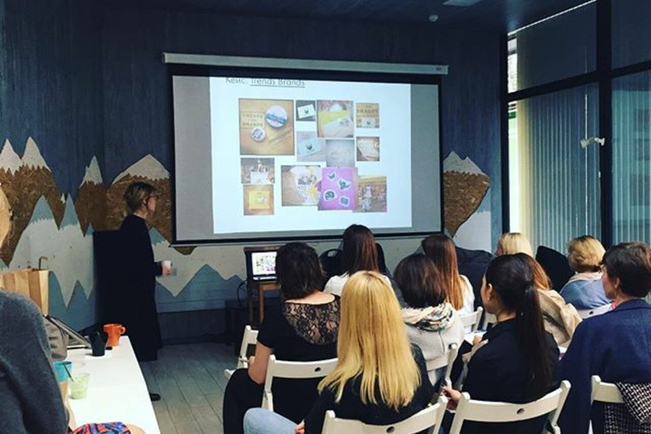 Арендовать Стильный лофт в скандинавском стиле. Вход с улицы. Люди на конференции смотрят на большой экран.