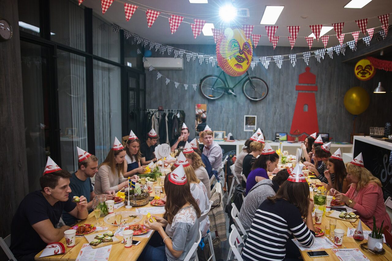 Арендовать Стильный лофт в скандинавском стиле. Вход с улицы. Праздничный стол на день рожденья, гости в бумажных колпаках.