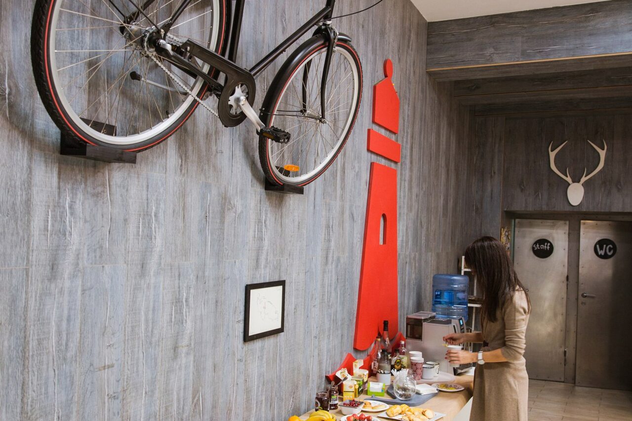 Арендовать Стильный лофт в скандинавском стиле. Вход с улицы. Велосипед на стене лофта - декор праздничного банкета. 