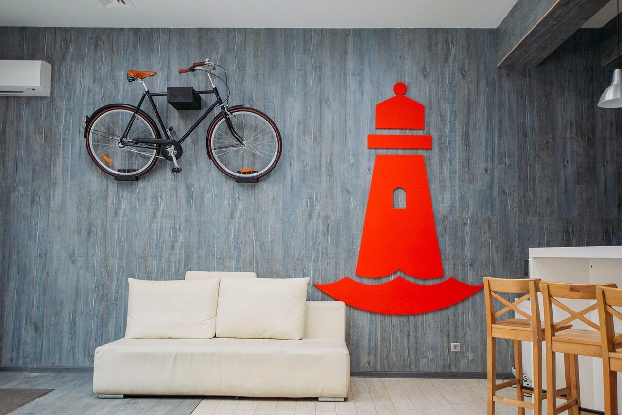 Арендовать Стильный лофт в скандинавском стиле. Вход с улицы. Лофт без людей с белым диваном и великом на стене.