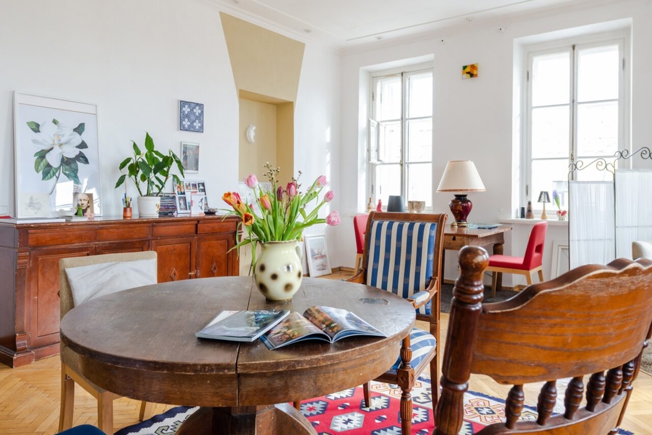 Арендовать Светлый лофт с панорамным видом. Светлый зал. Круглый стол с цветком и журналами