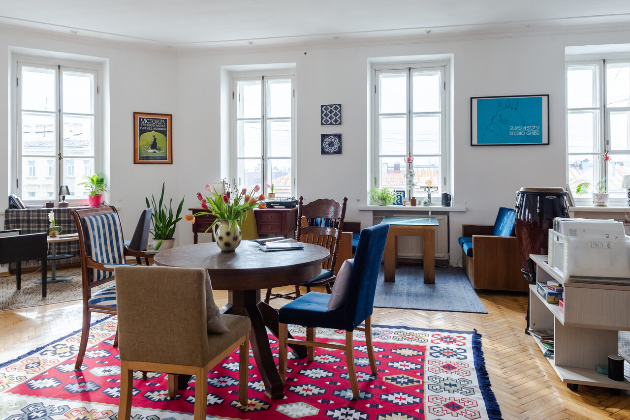 Арендовать Светлый лофт с панорамным видом. Столы со стульями. Ковры на полу. Различные элементы декора