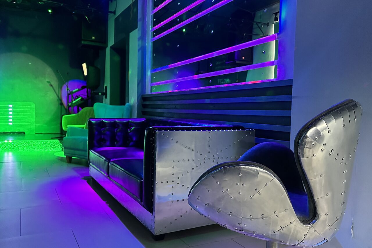 Арендовать Музыкальный лофт на Тульской. Диваны с подушками, зеркальная стена, сцена, проекция на стену.