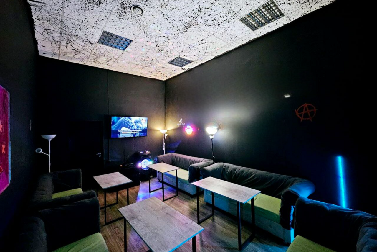 Арендовать Типичный Питер. Тёмный лофт с логотипами групп 90-х