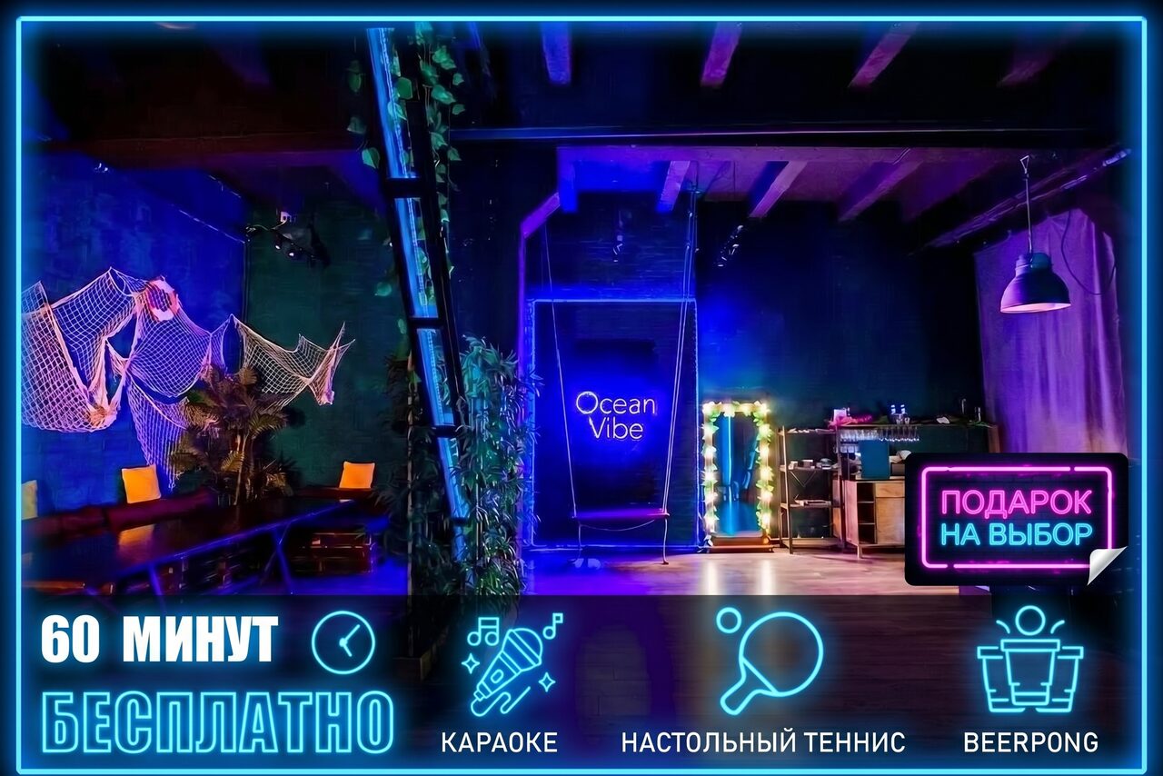 Арендовать Тематический лофт лагуна. Пространство с высоким потолком и темным интерьером, украшенное сетками и растениями. На стене неоновая надпись "Ocean Vibe". Мебель включает диван и столы. Неоновая вывеска "Подарок на выбор", освещение разноцветное с акцентом на синий. Текст: "60 минут бесплатно", "Караоке", "Настольный теннис", "Beerpong".