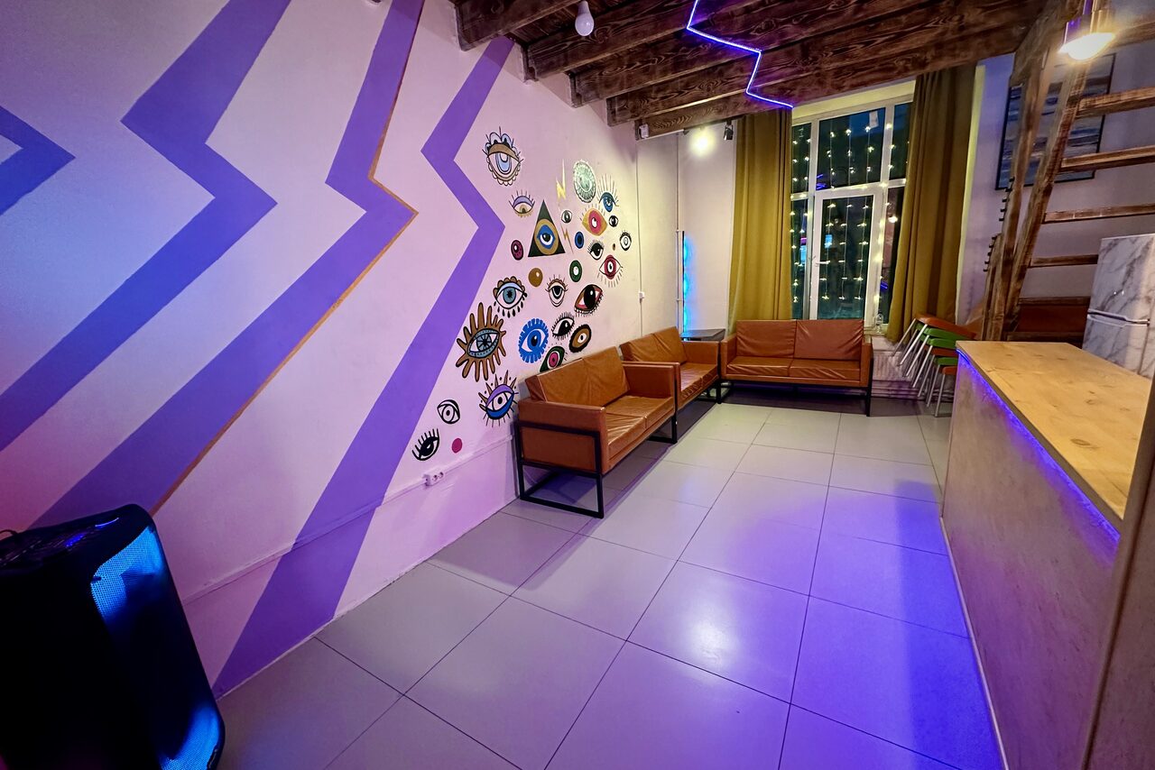 Арендовать Яркий двухуровневый лофт. Разукрашенные стены с рисунками. Диваны. В углу колонка. Барная стойка