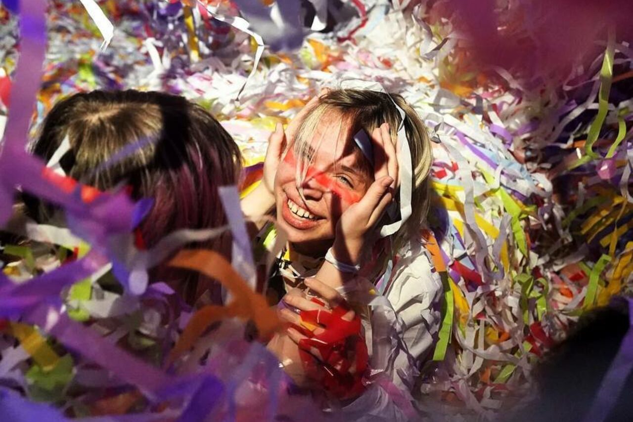 Арендовать Лес. Театральный лофт с верандой, сценой и вторым ярусом. Не удается предоставить фактическое описание пространства, мебели или оборудования. Видны разноцветные ленты бумаги, окружающие людей. Освещение мягкое.