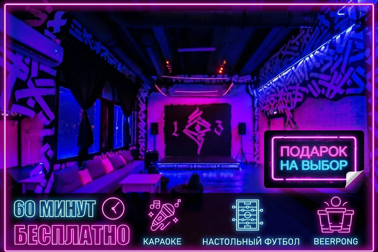 Арендовать Мультиформатный лофт-зал. Просторная комната для мероприятий с неоновым освещением, граффити на стенах, мягкими диванами вдоль окна и сценой. На переднем плане неоновая вывеска "Подарок на выбор". Тексты: "60 минут бесплатно", "Караоке", "Настольный футбол", "Beerpong".