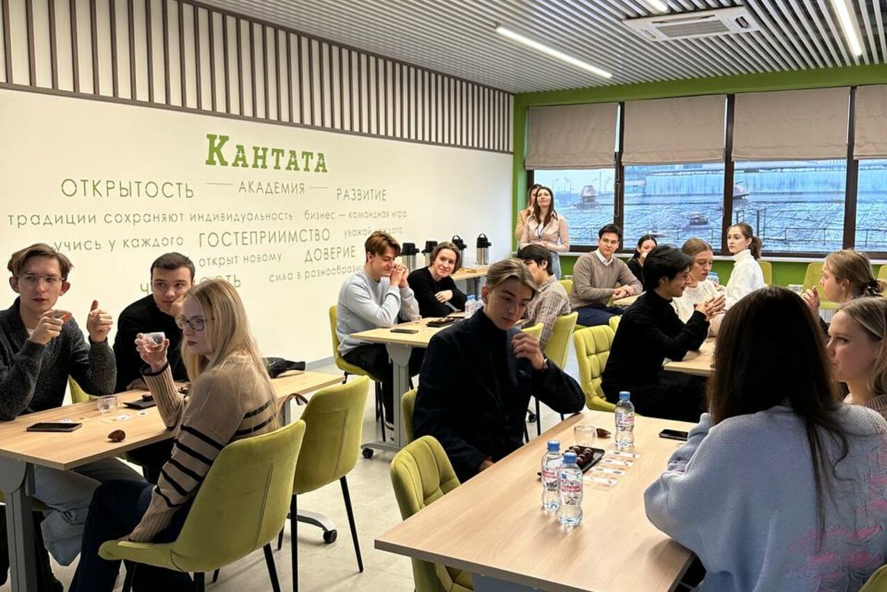 Арендовать Зал 6. Просторный и светлый конференц-зал до 50 человек в Академии Кантаты. Современное учебное помещение с несколькими прямоугольными столами и зелеными стульями. На стене надпись: "Кантата", "Открытость", "Академия", "Развитие". Большие окна с жалюзи, искусственное потолочное освещение. Стены светло-серые и зеленые.