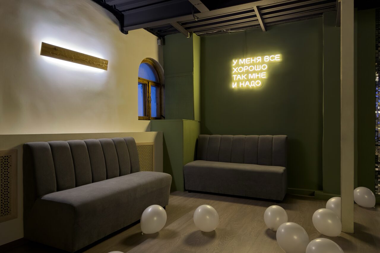 Арендовать Maybe Loft (Мэйби Лофт). Зал Olive (Олив). Современный дизайнерский лофт . Пространство с мягкими серыми диванами, зелеными стенами, декорированное светящейся надписью. На полу разбросаны белые воздушные шары. Стена с арочным окном, светодиодное освещение.