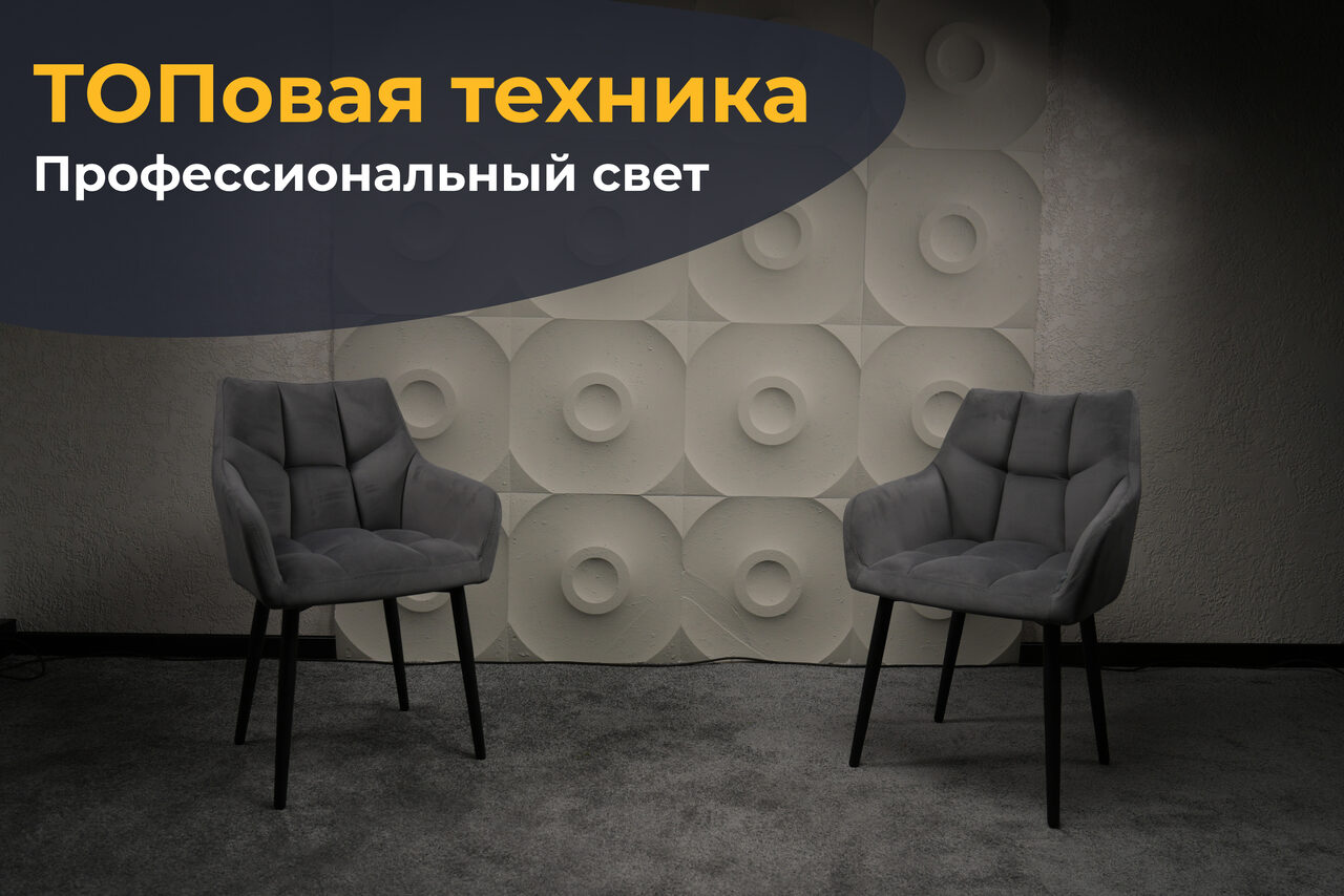 Арендовать Лофт  Эйфория. Современное пространство с двумя серыми стульями на сером ковре. Стена с объемным геометрическим узором в виде круглых элементов. Наверху текст: "ТОПовaя техника" и "Профессиональный свет". Освещение мягкое, равномерное.