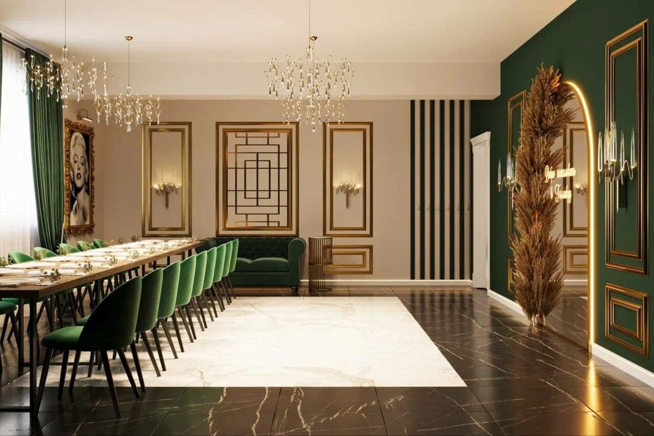 Арендовать Голливуд. Элегантный лофт в зелено-бежевых оттенках. Просторное помещение с длинным обеденным столом, окруженным зелеными стульями. Потолочные люстры, темные пол и стены, акцентная стена зеленого цвета с золотыми рамами. На полу ковровая вставка светлого цвета. Декоративные зеркала.