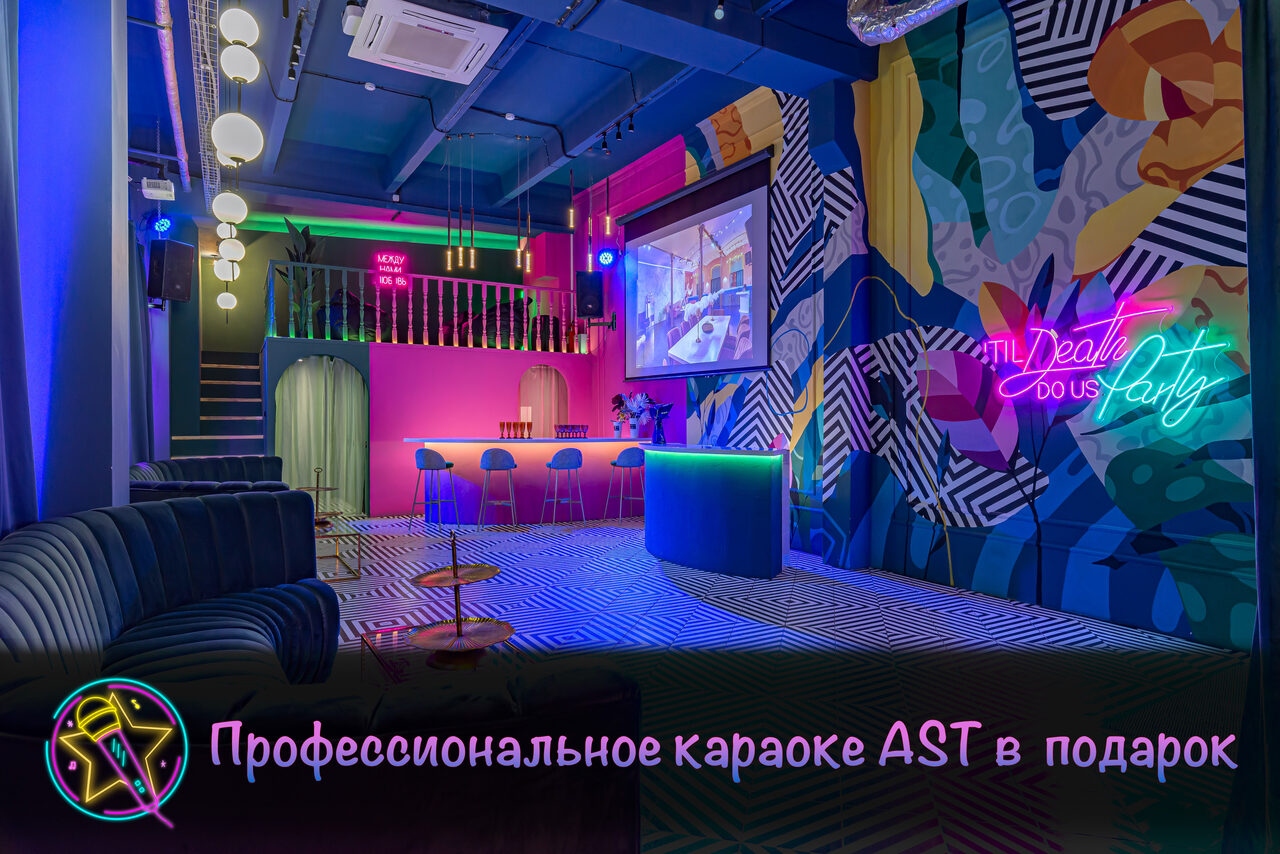Арендовать Лофт Май. Зал Мира. Караоке-зал с ярким освещением, неоновыми вывесками, разноцветными стенами и потолком. Барная стойка с высокими стульями, удобные диваны, подвешенные круглые светильники. На стене имеется экран и цветной текстильный фон.